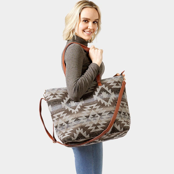 over the shoulder strap bag in a large square shape with additional long strap. diamond woven pattern in grey flannel