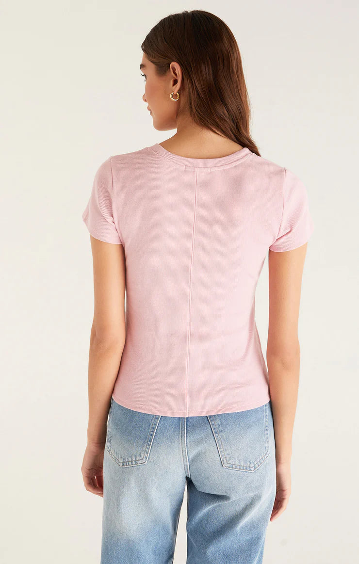 Back view of pink top. You can see the ribbed materal, short sleeves and a center seam running down the entire back. Hem hits the model at the top of her back jean pockets.