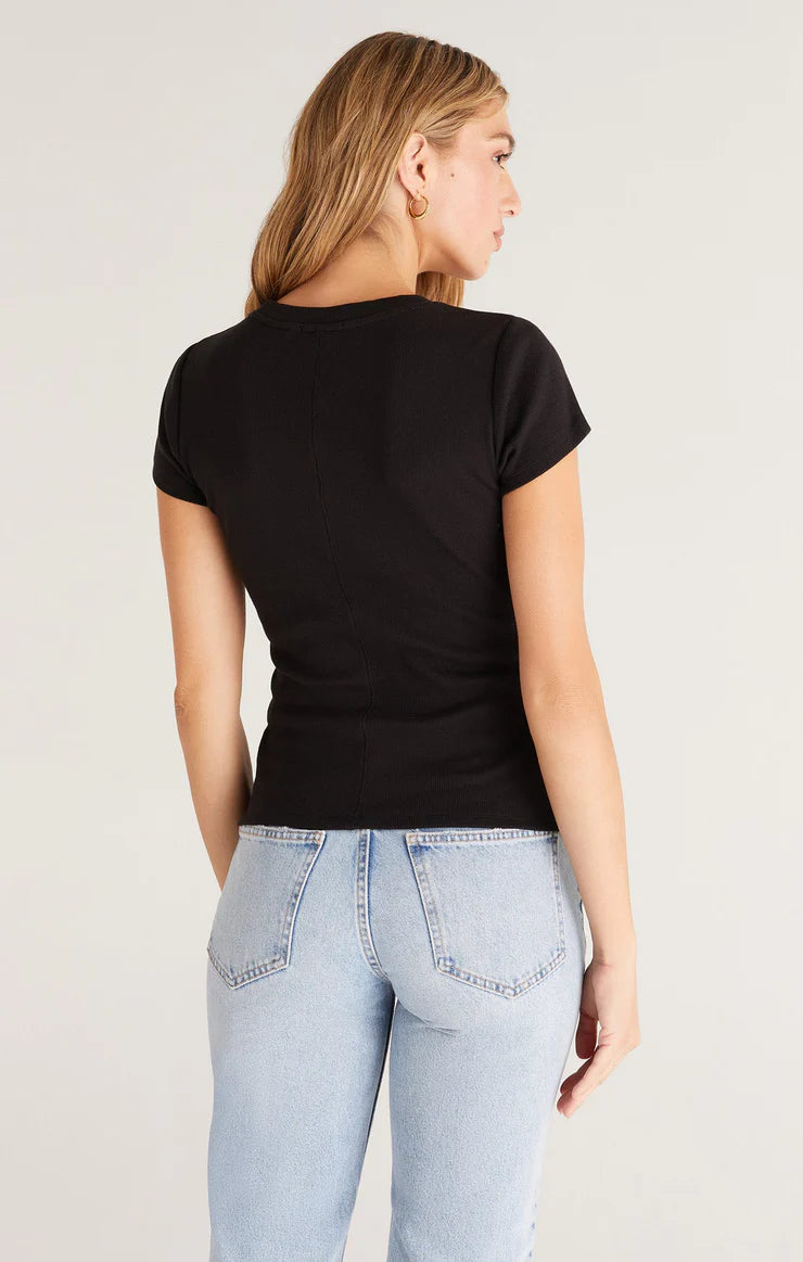 Back view of black top. Shows a center seam running down the entire back. Shows fitted silhouette. Hits model at top of her jeans back pockets.