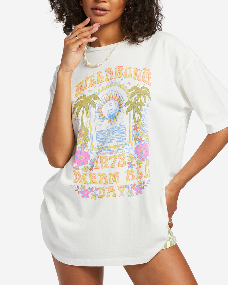 shows front view of tee featuring a high crew neck, oversized fit, and colorful summer graphic.