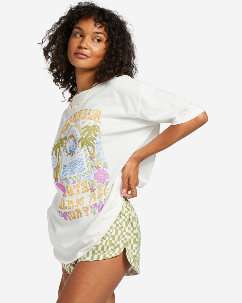 shows angled view of tee featuring a high crew neck, oversized fit, and colorful summer graphic.
