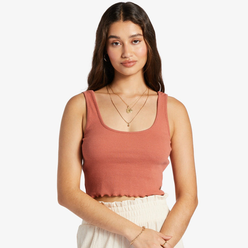 shows front view of model in the redwood tank top. shows the square neckline, thick straps, ribbed fabrication and lettuce edge hemline. hits model above belly button.