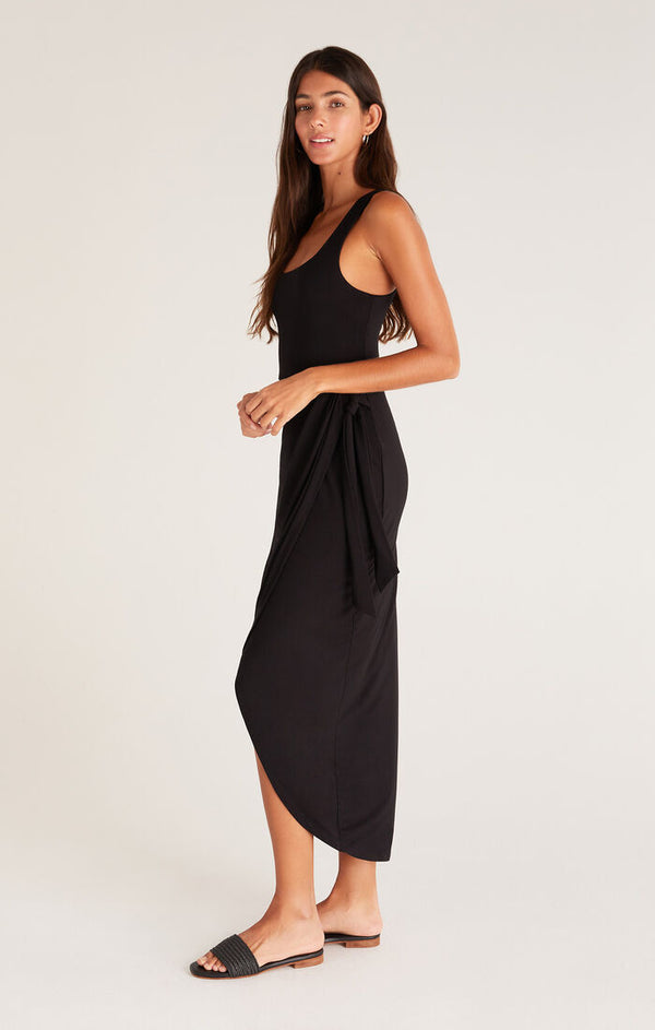 side view of midi dress with square neckline, wide straps, hi-low wrap skirt, and a side tie detail. 