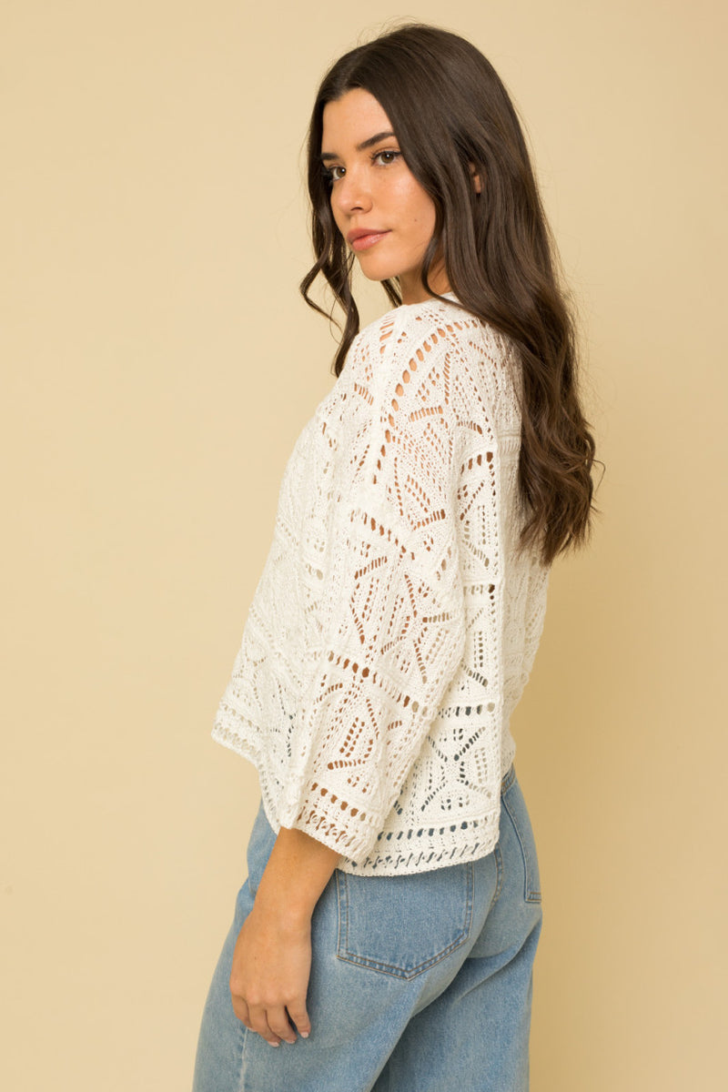 shows side view of crochet 3/4 sleeve blouse.