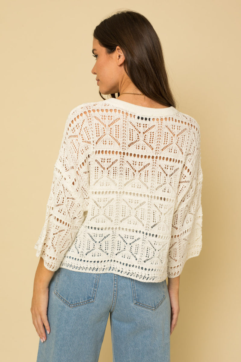 shows back view of crochet top with 3/4 length bell sleeves.